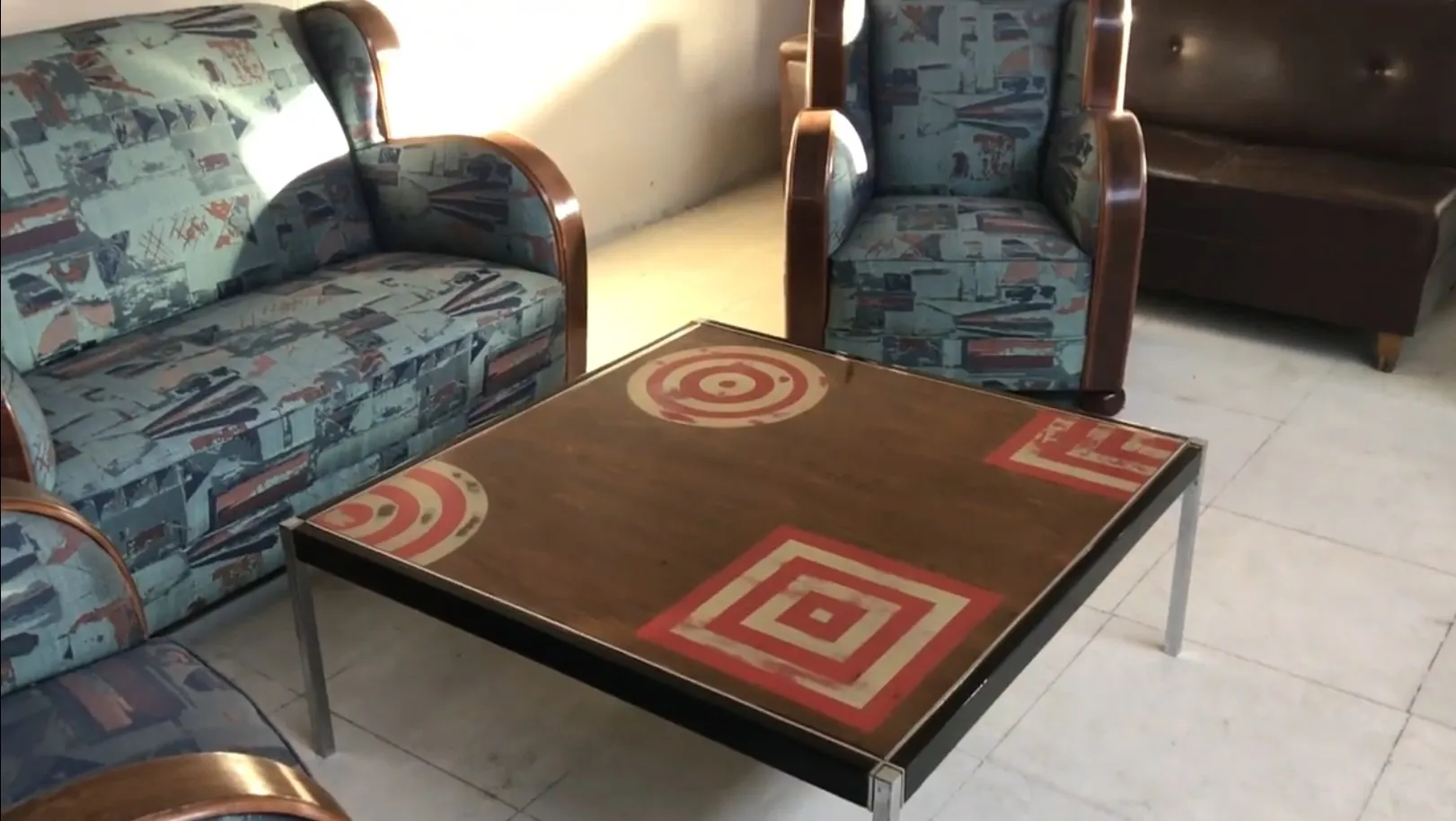 mesa ratona antigua con patrones geométricos en la superficie, rodeada de sillones