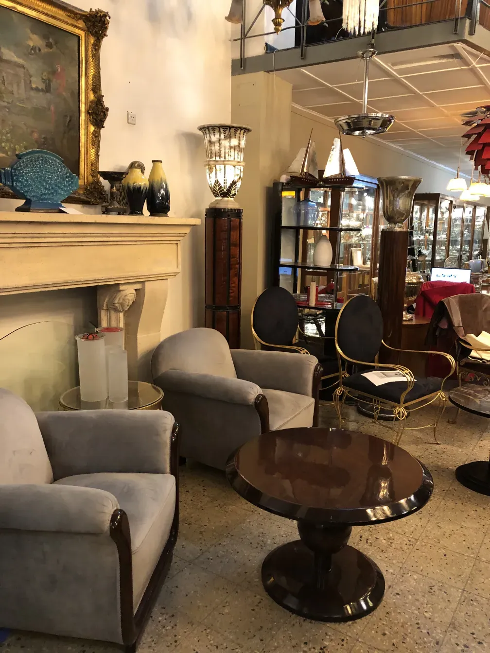 Mesa de centro antiga em um ambiente com cadeiras macias e decoração clássica.