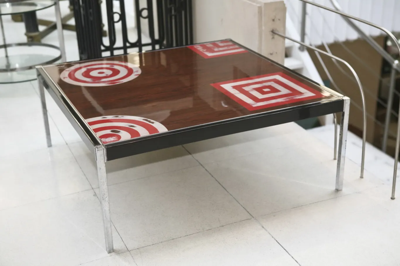 Table basse antique avec design géométrique en haut, entourée d'un environnement élégant
