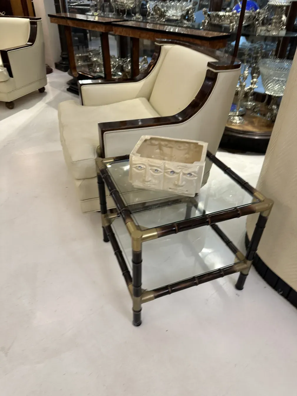 mesa de centro antiga com tampo de vidro e estrutura notável, em um ambiente elegante