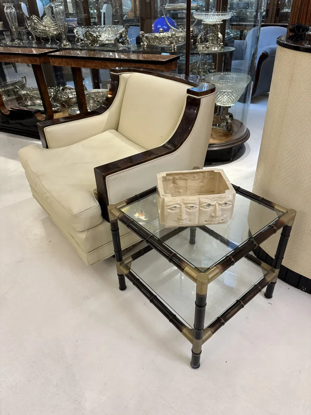 Tres mesas ratonas antiguas junto a un sillón blanco y objetos decorativos