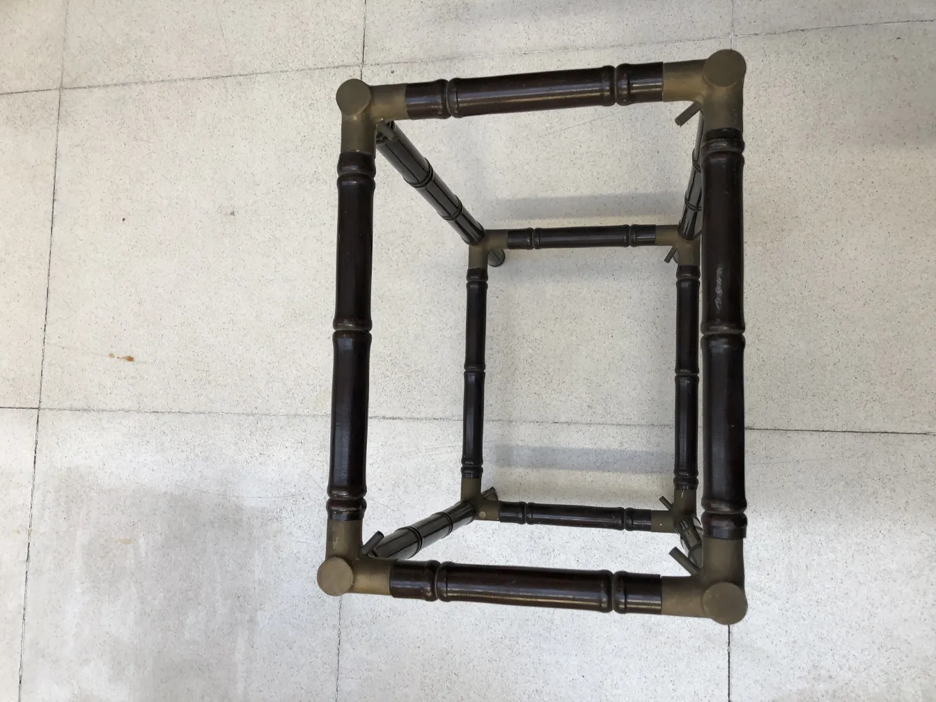 Antique small table with decorative structure and intricate legs.