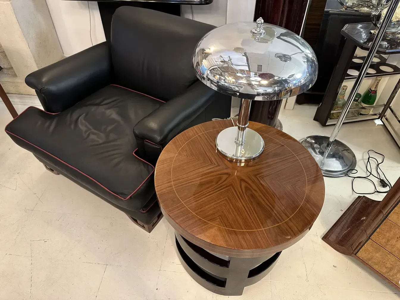 Petite table d'antiquité avec plateau rond et base métallique, dans un cadre moderne.