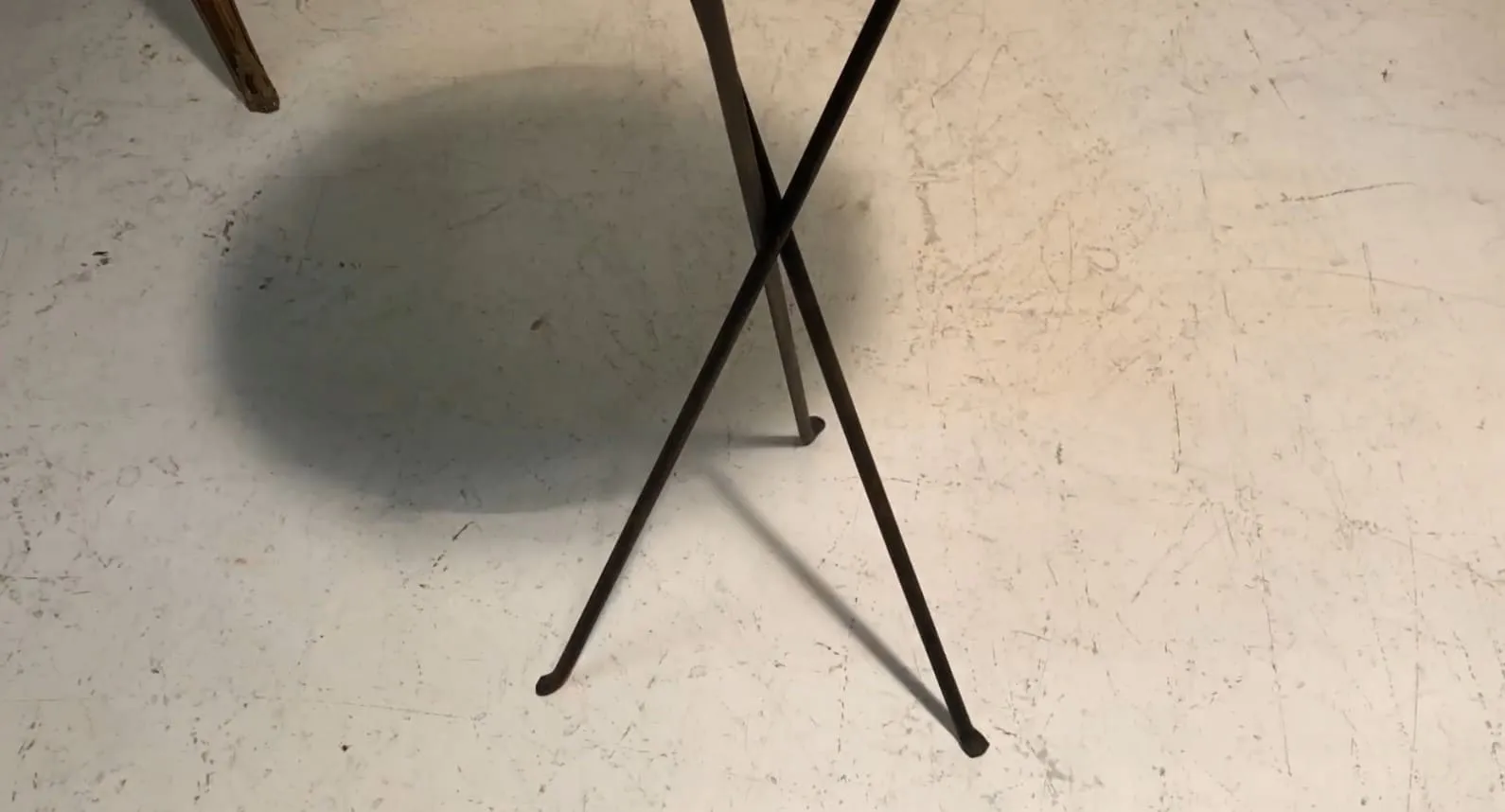 mesita antigua con patas cruzadas en un ambiente neutral