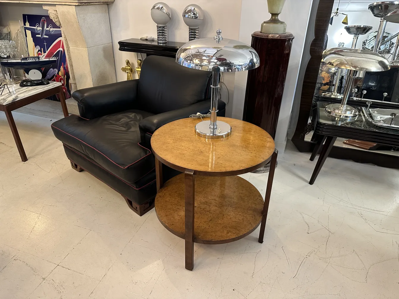 ancienne petite table ronde avec étagère dans un cadre classique avec canapé noir