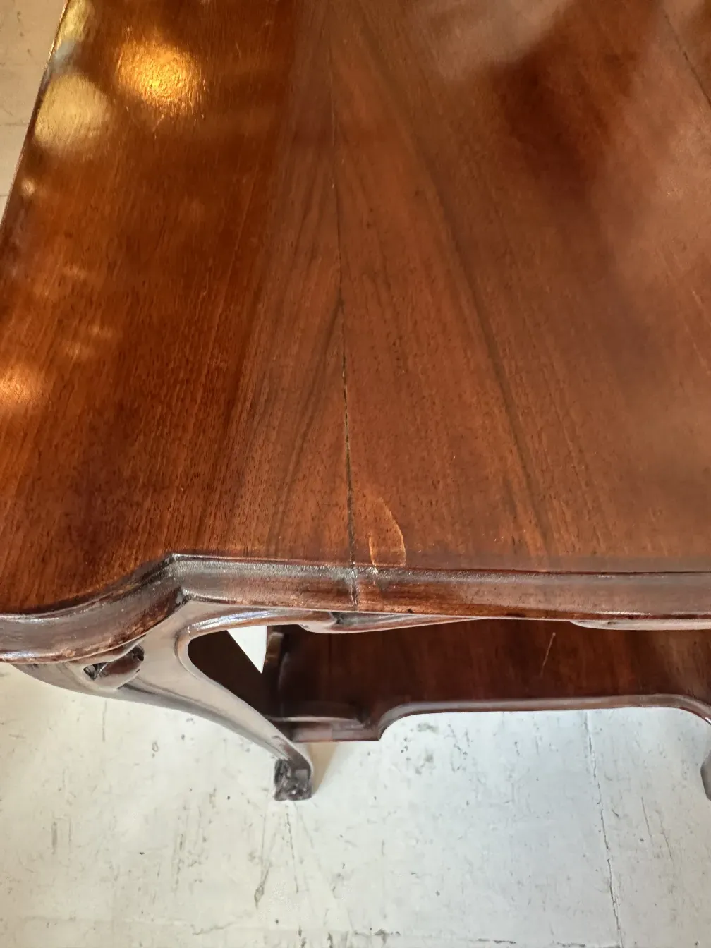 petite table ancienne avec surface brillante et pieds courbés, ambiance sereine