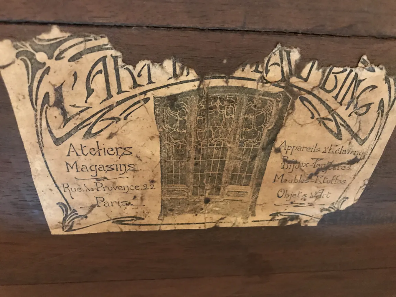 Mesita antigua con secciones de papel desgastado de Atelier Bing en París, se observa un estilo antiguo