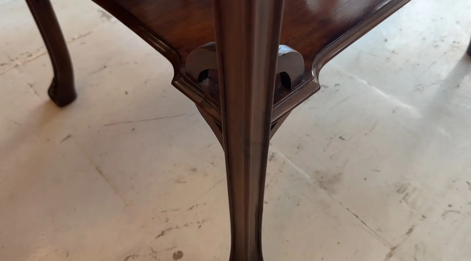 Antique small table with elegant legs in a light setting
