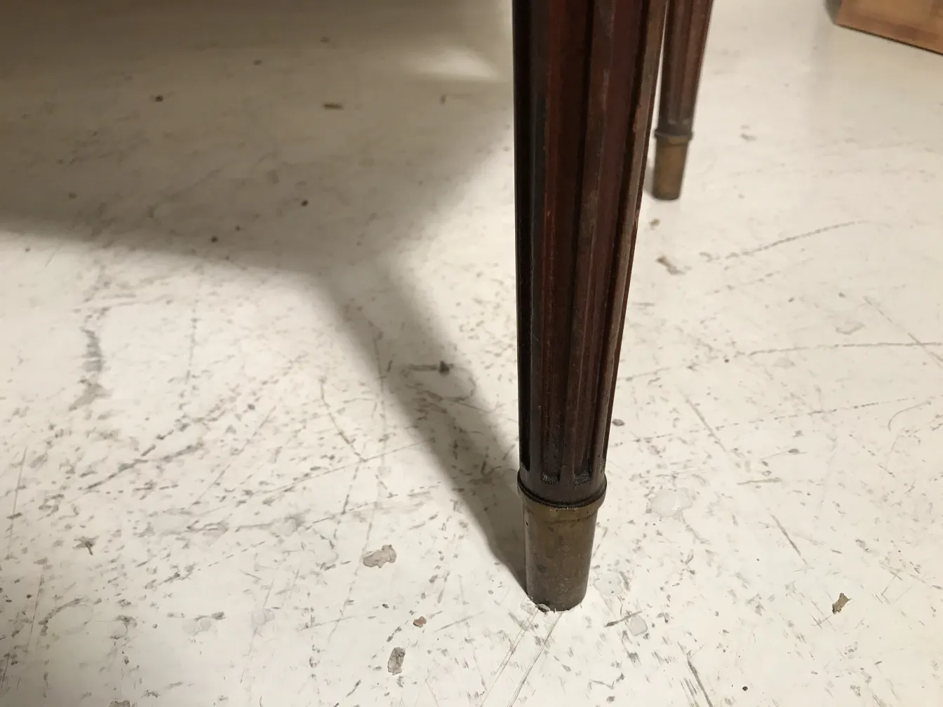 mesita antigua de tres patas con detalles decorativos