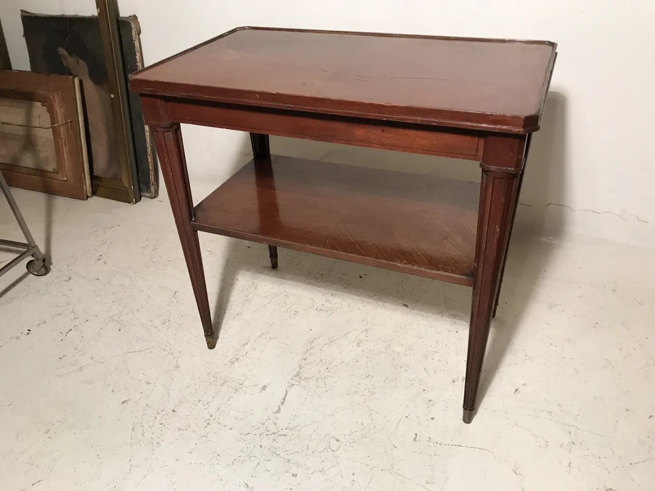 Tavolino antico di Nordiska Kompaniet con ripiano inferiore in un ambiente di antiquariato.