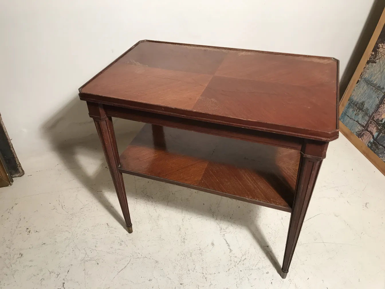 Petite table antique de Nordiska Kompaniet avec des pieds élégants, fond neutre.