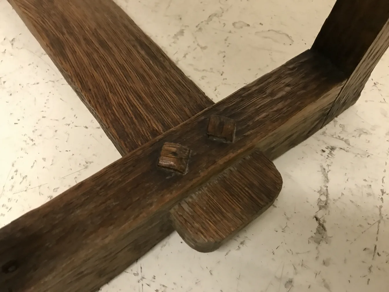 vista detallada de una mesita antigua con estructura simple en un fondo neutro