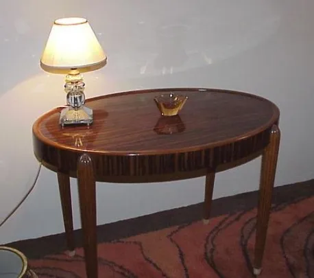Petite table ancienne ovale avec décoration et lampe
