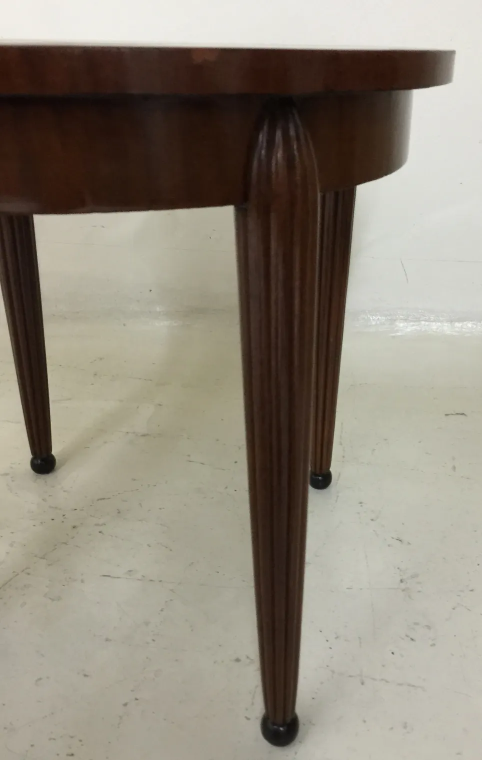 mesita antigua de forma redonda con patas elegantes