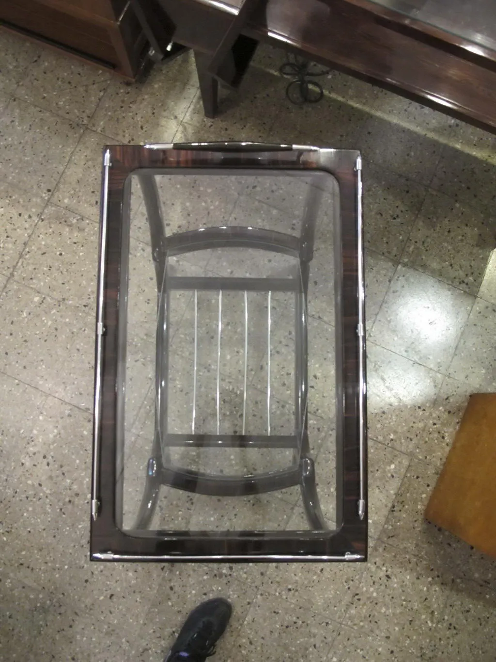 Petite table ancienne en forme de trèfle, dans un cadre accueillant avec des meubles sombres et un sol en mosaïque