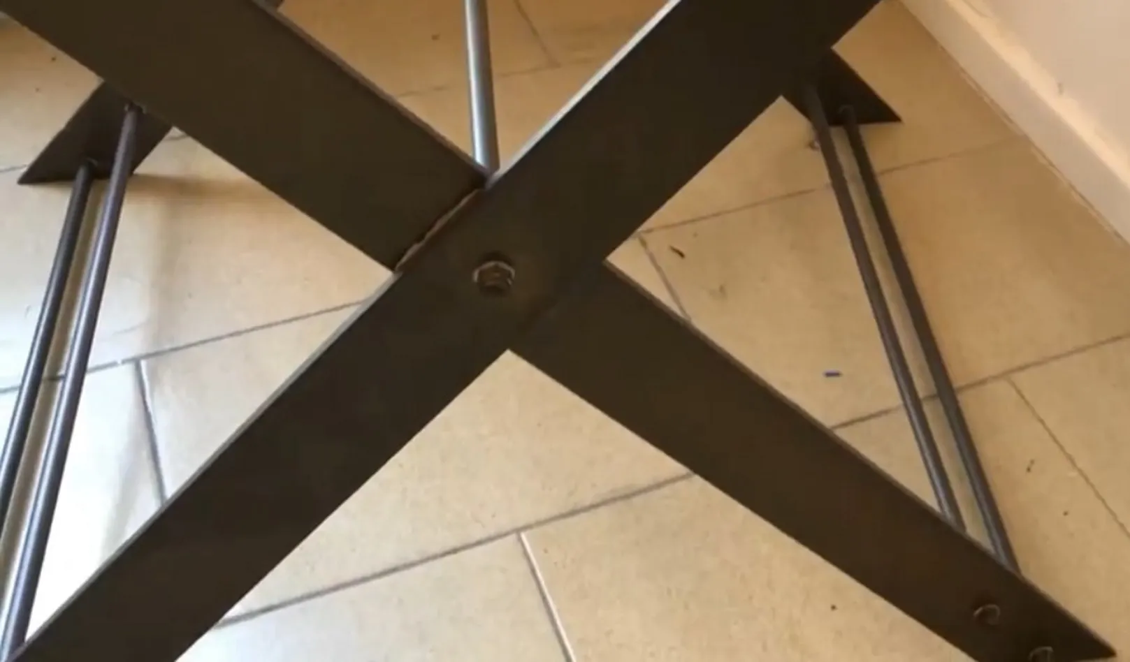 Mesinha antiga com pernas cruzadas, ambiente simples.