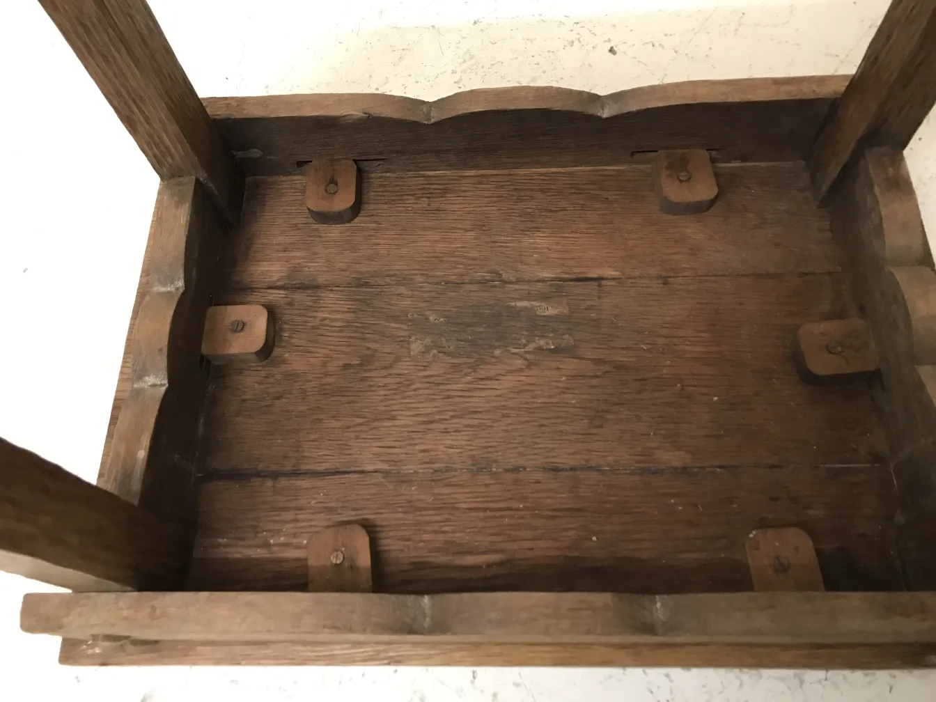 Mesita antigua con un diseño simple y elegante en un entorno claro.