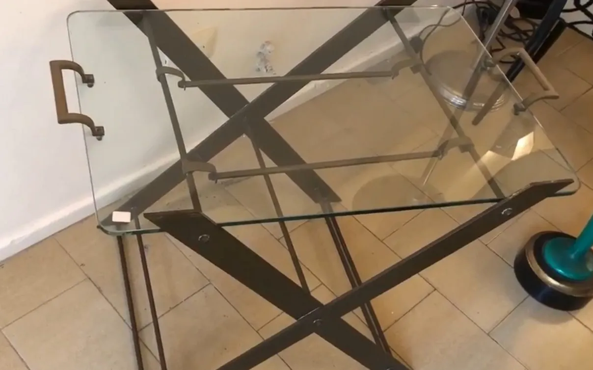 mesinha antiga com tampo de vidro e pernas elegantes em um ambiente aconchegante