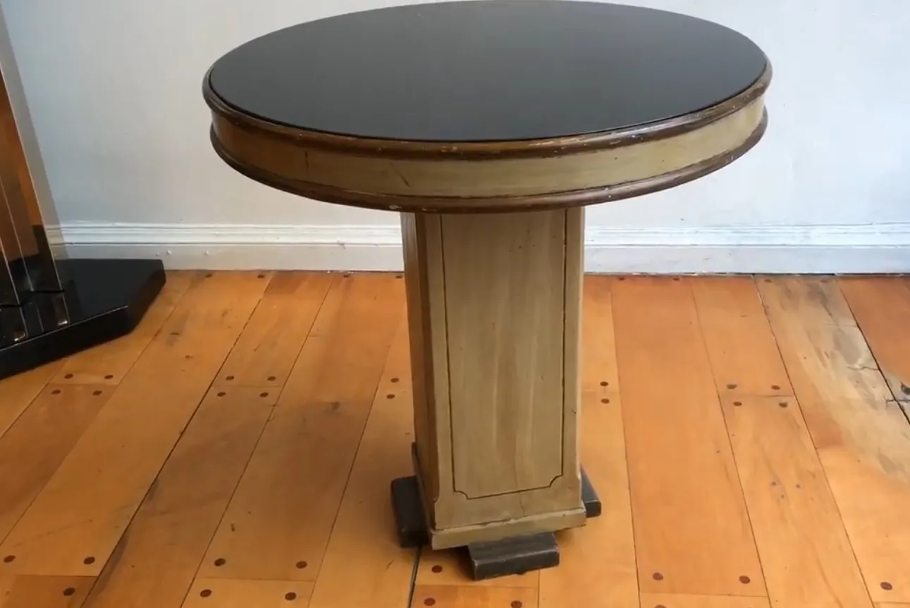 Petite table ronde ancienne avec une base solide dans un cadre chaleureux.