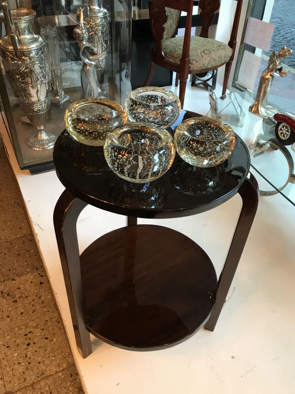 Mesita antigua con diseño minimalista y decoraciones sutiles, acompañada de frascos decorativos.