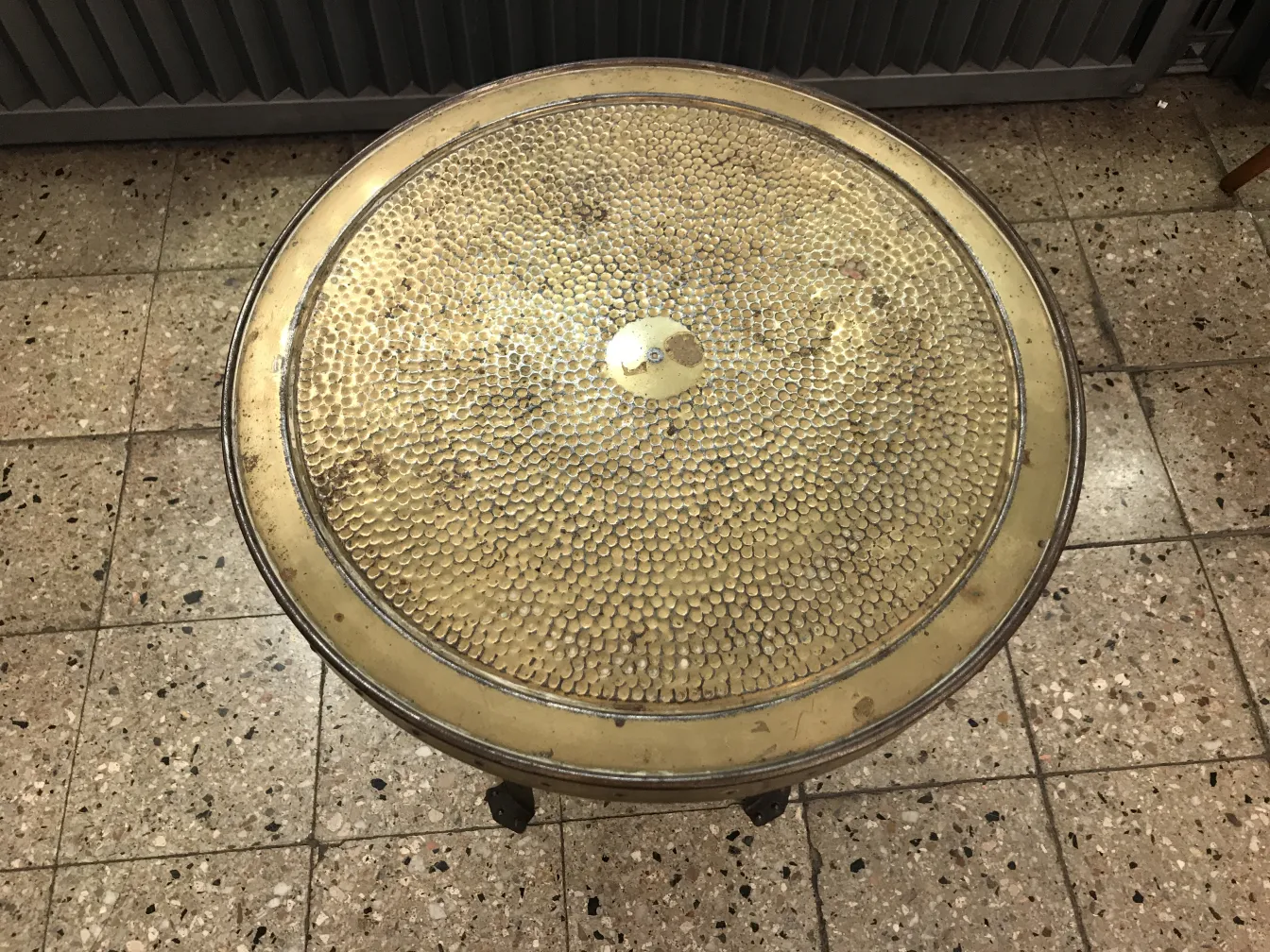 Tavolino antico rotondo con dettagli decorativi, ambiente classico