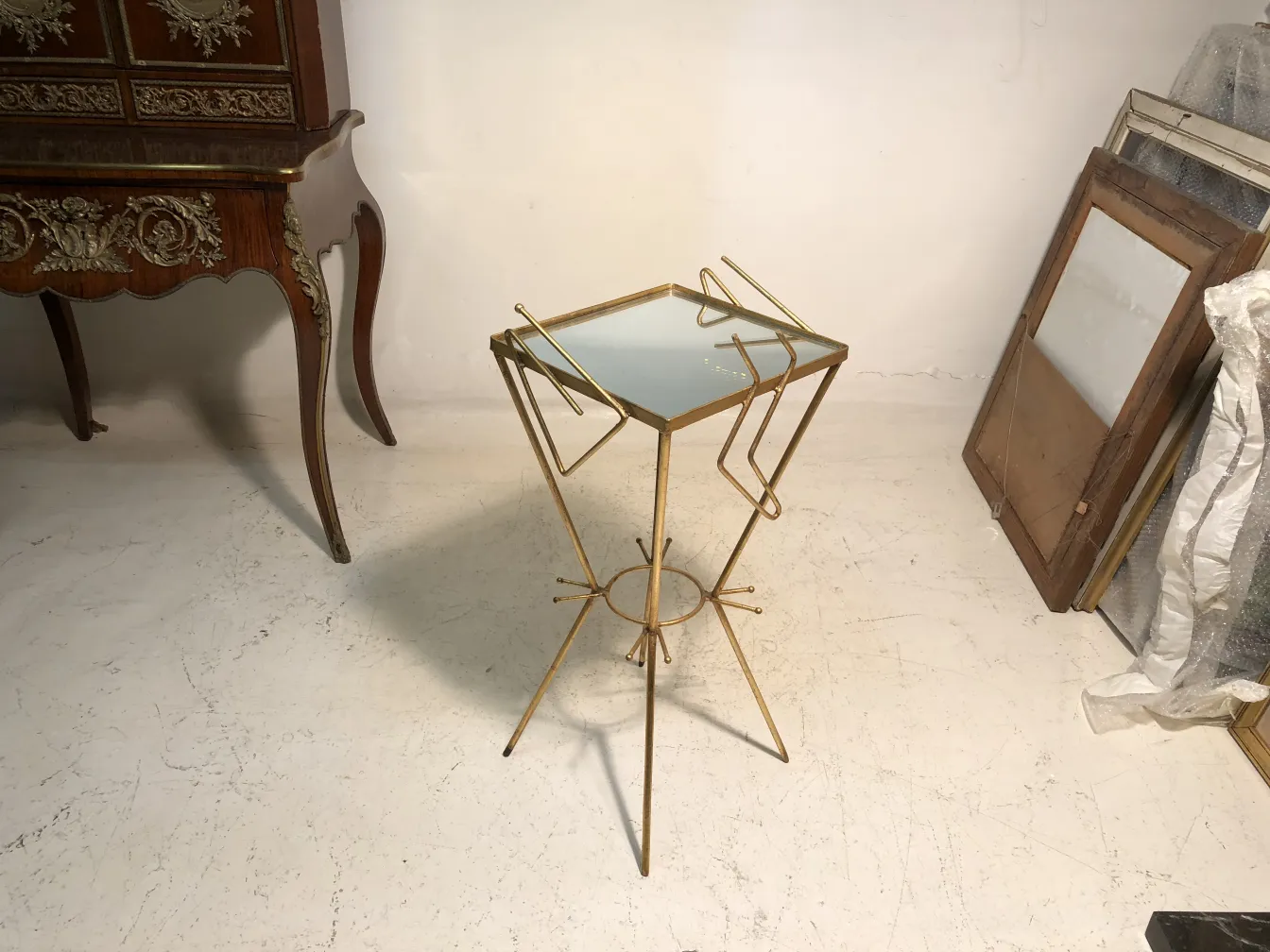 petite table ancienne au design minimaliste et aux pieds fins, dans un cadre chaleureux avec des meubles vintage
