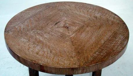 Antique round small table with detailed surface design.