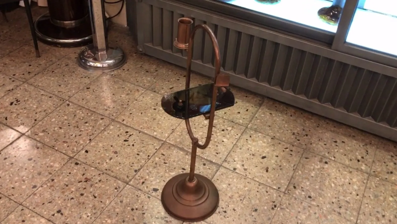 petite table ancienne avec dessus noir et base ronde, dans un cadre accueillant