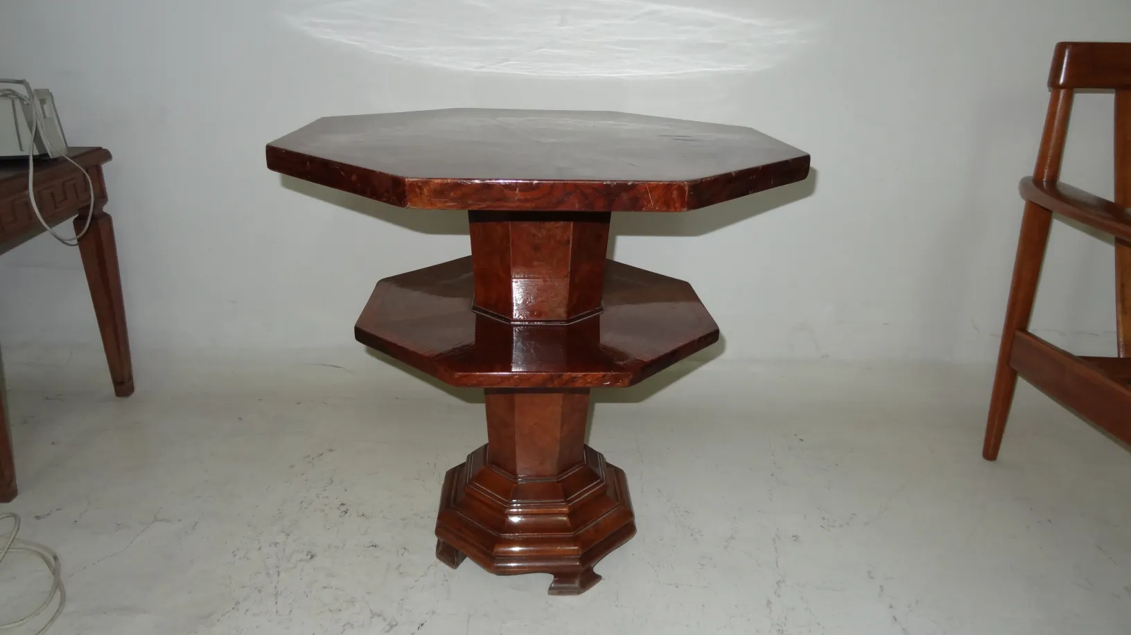 Petite table ancienne octogonale avec base distinctive dans un cadre simple