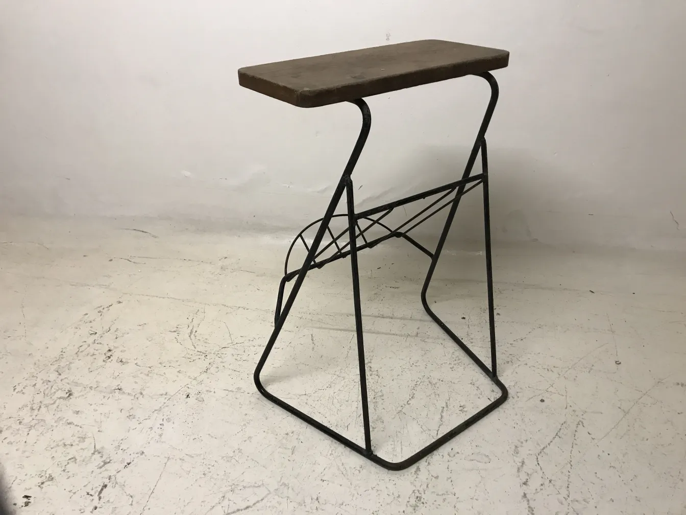 Ancienne petite table avec une surface plate et une base métallique triangulaire