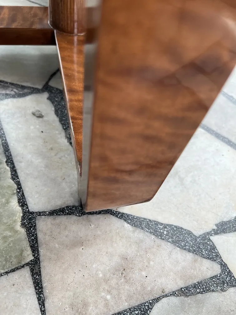 Detalle de una mesita antigua con decoración subida desde el suelo.