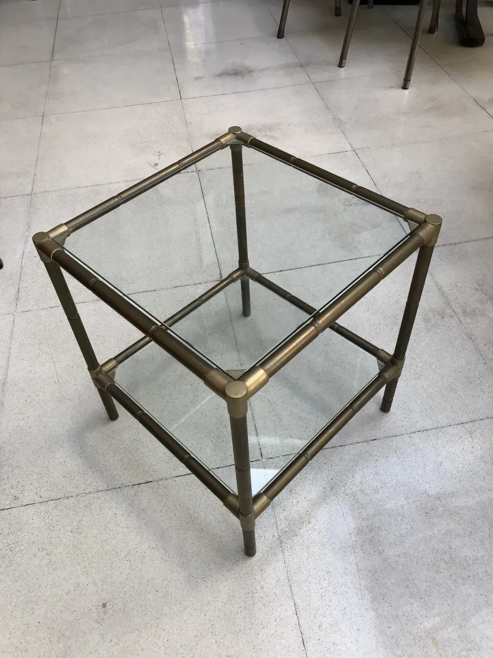 antiker kleiner Tisch mit Metallrahmen und Glas, in minimalistischer Umgebung