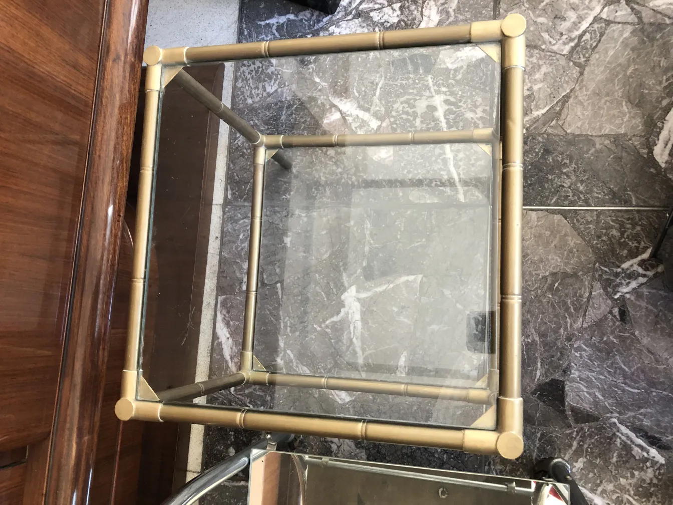 mesita antigua con estructura metálica y superficie de cristal clara