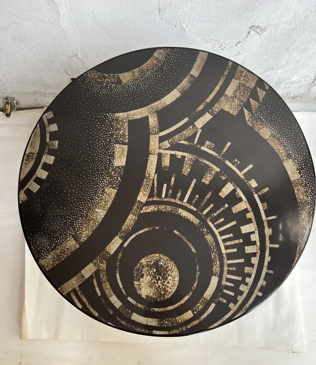 Runder antiker kleiner Tisch mit geometrischem Design in dunklen Tönen.