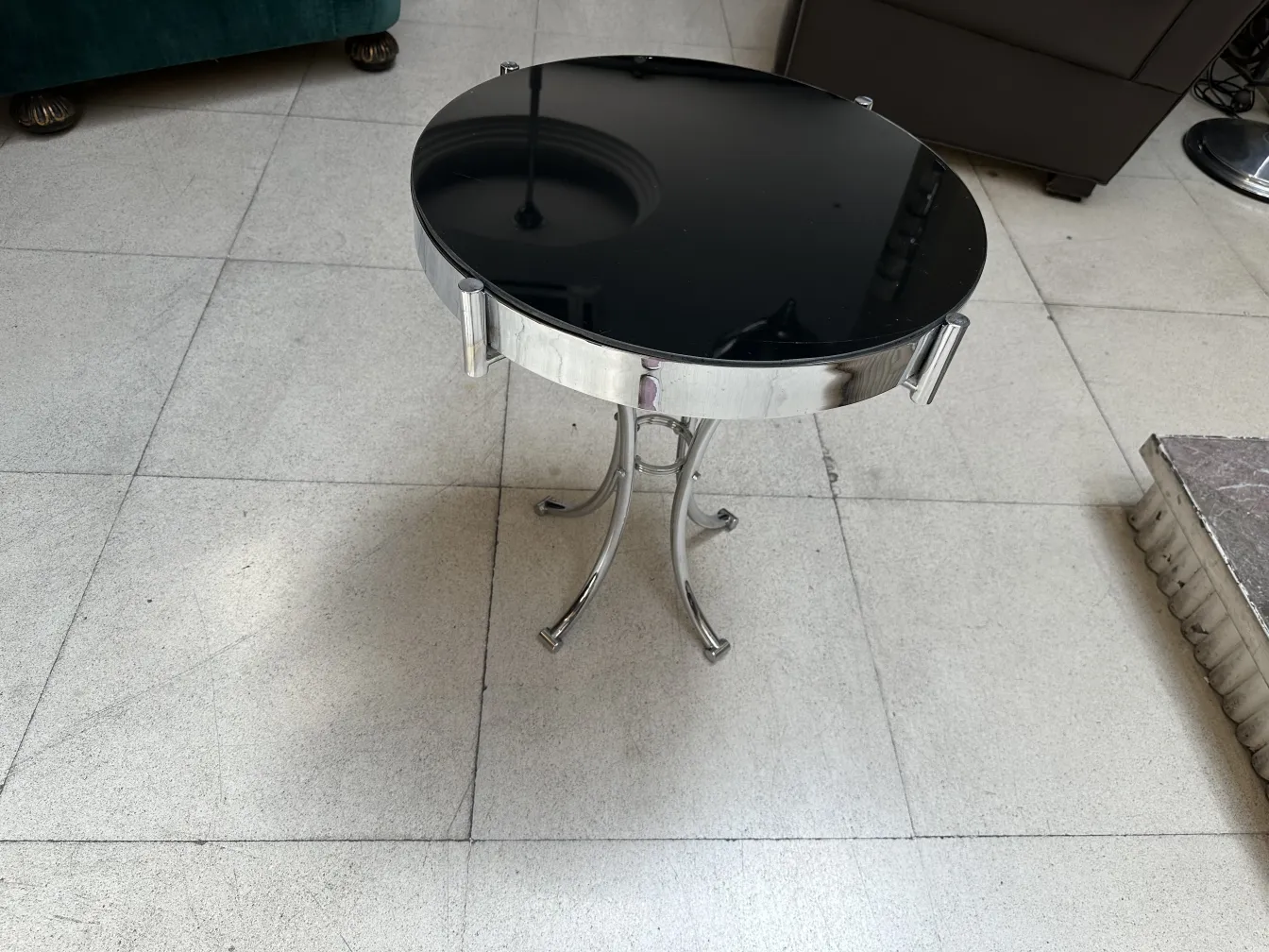 Antiker runder schwarzer Tisch mit silbernen Details, dekorativ und elegant.