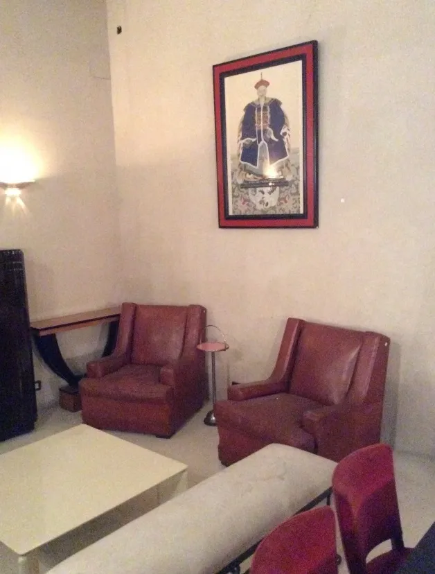 antique small table in a cozy setting with armchairs and artwork