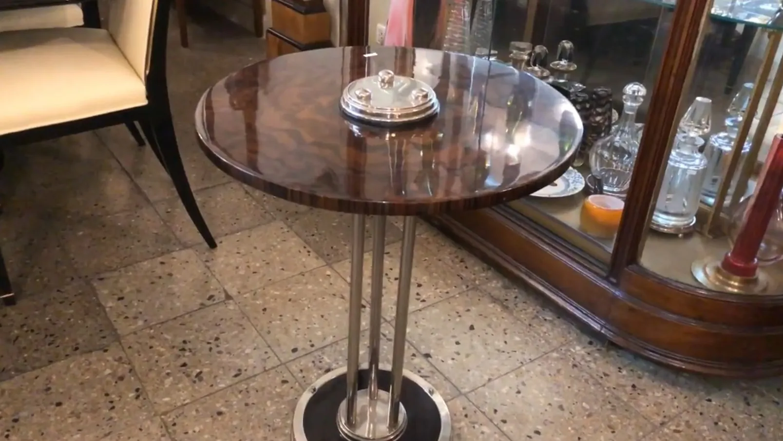 petite table ronde avec déco vintage et un objet argenté dessus, ambiance chaleureuse