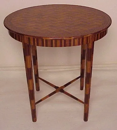 Mesinha redonda antiga com design em zigzag no topo e pernas decorativas.