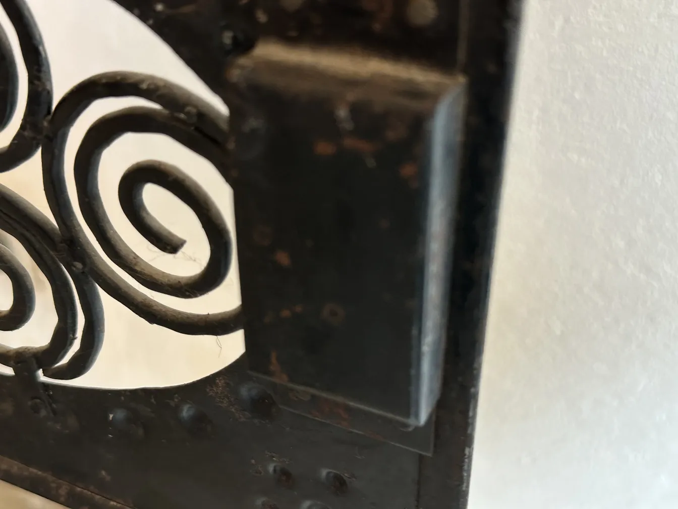 Dettaglio di un tavolino antico con design decorativo a spirale.