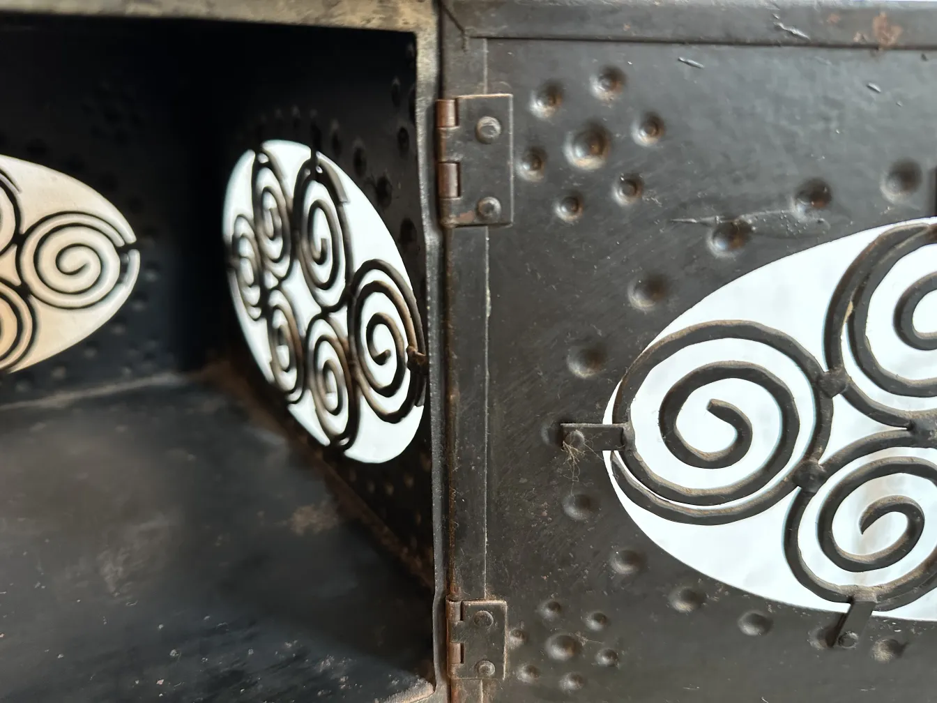 antigua mesita con decoraciones en espiral, fondo oscuro