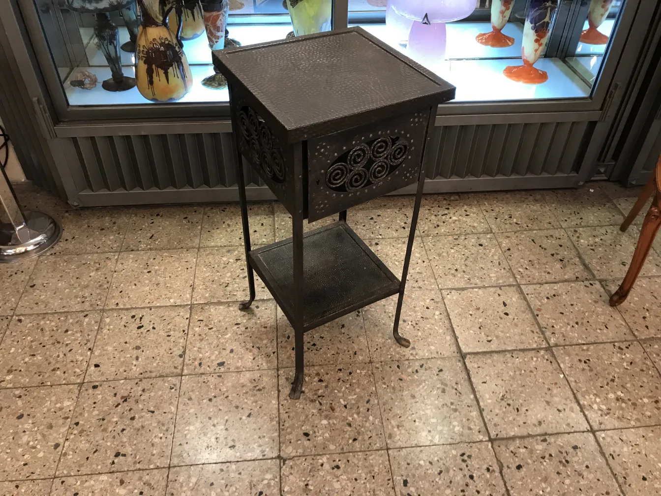 Antique small table with iron design, elegant look in an antique setting.