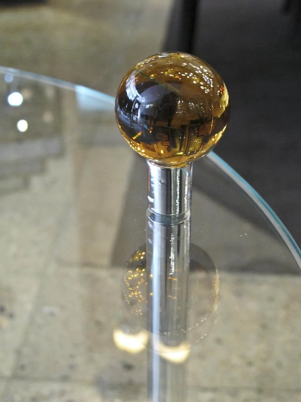 Mesa pequeña antigua con bola de cristal en la base, ambiente acogedor