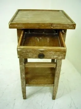 Antico tavolino con cassetto, con un design semplice e funzionale in un ambiente neutro.