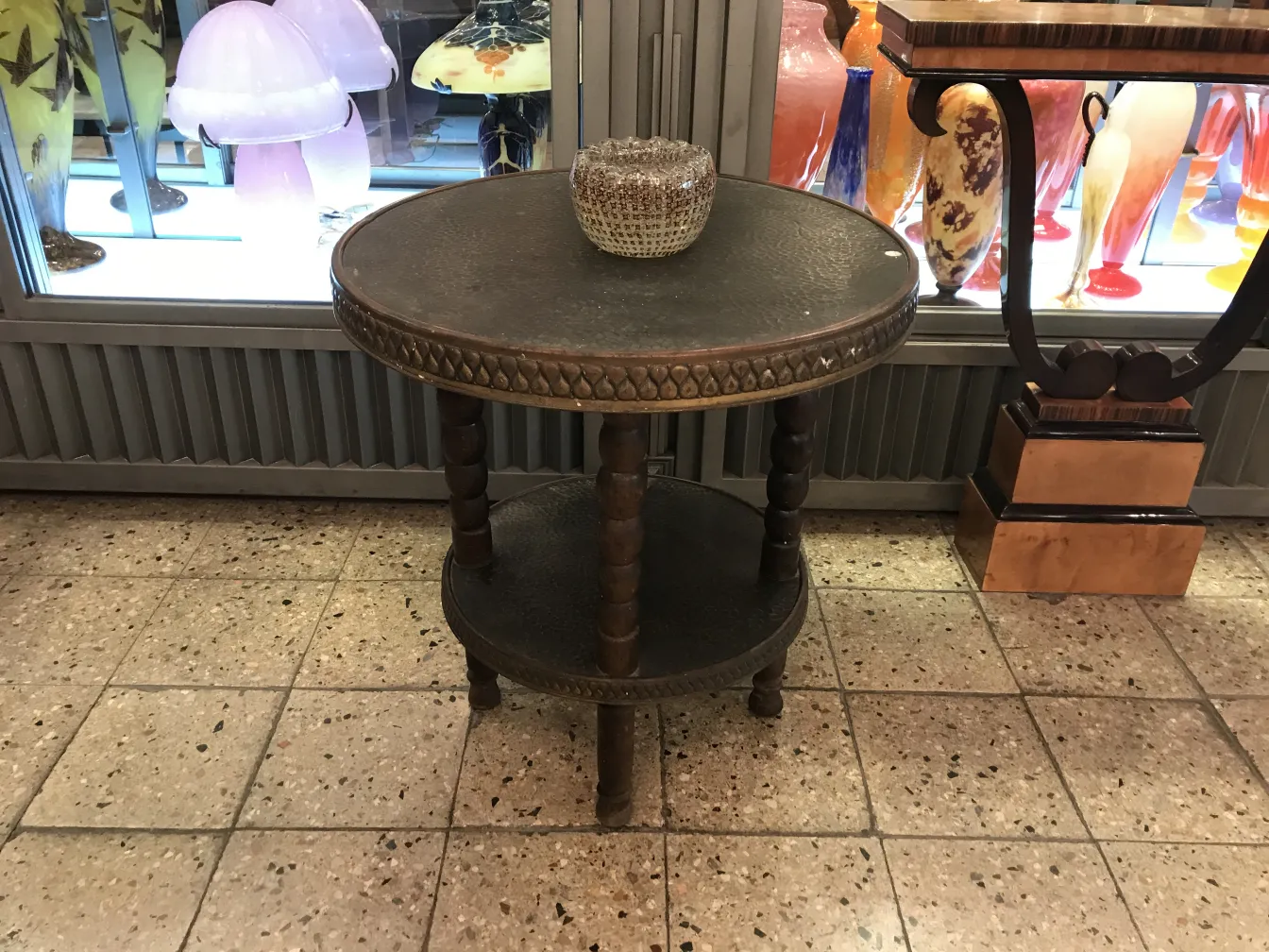 Mesinha antiga decorativa com superfície redonda e detalhes esculpidos