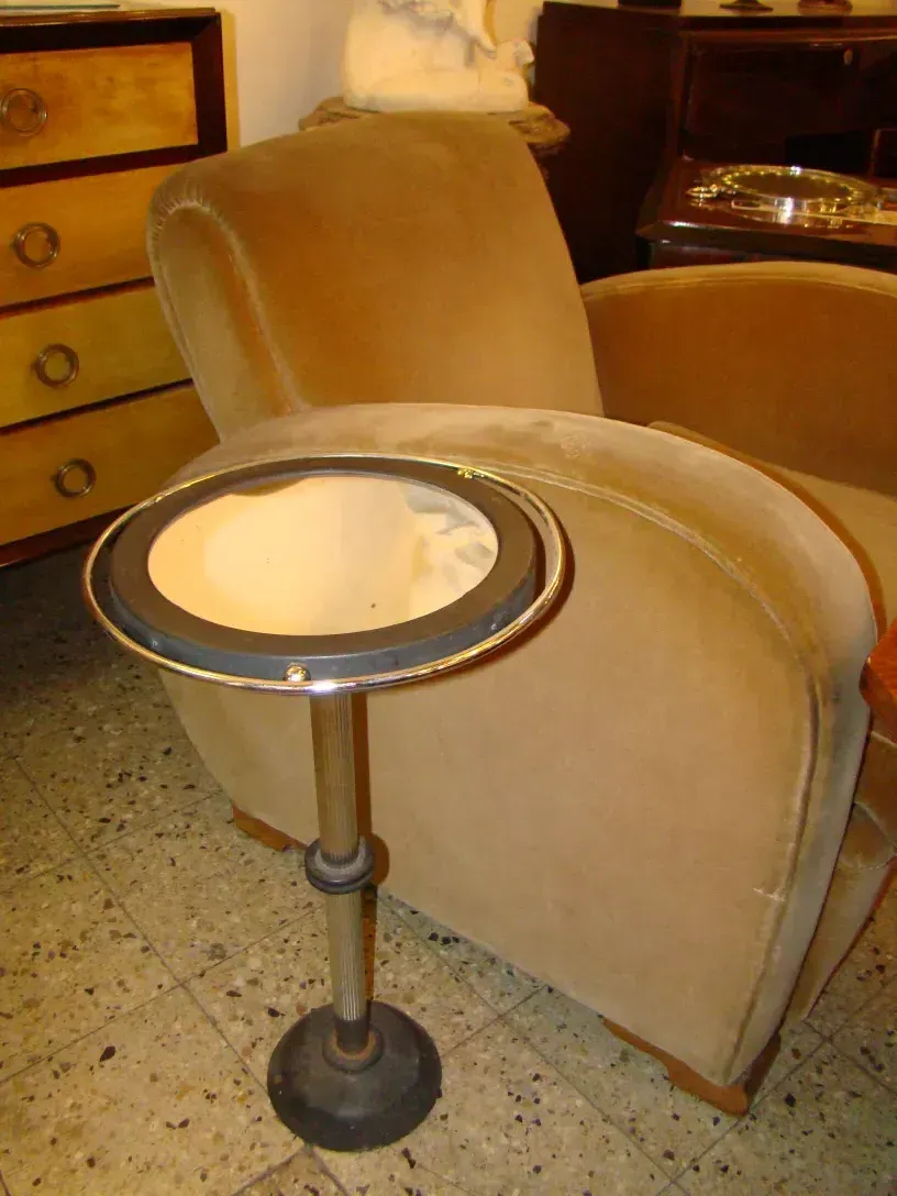 petite table ancienne avec miroir en argent, à côté d'une chaise douce dans un cadre chaleureux