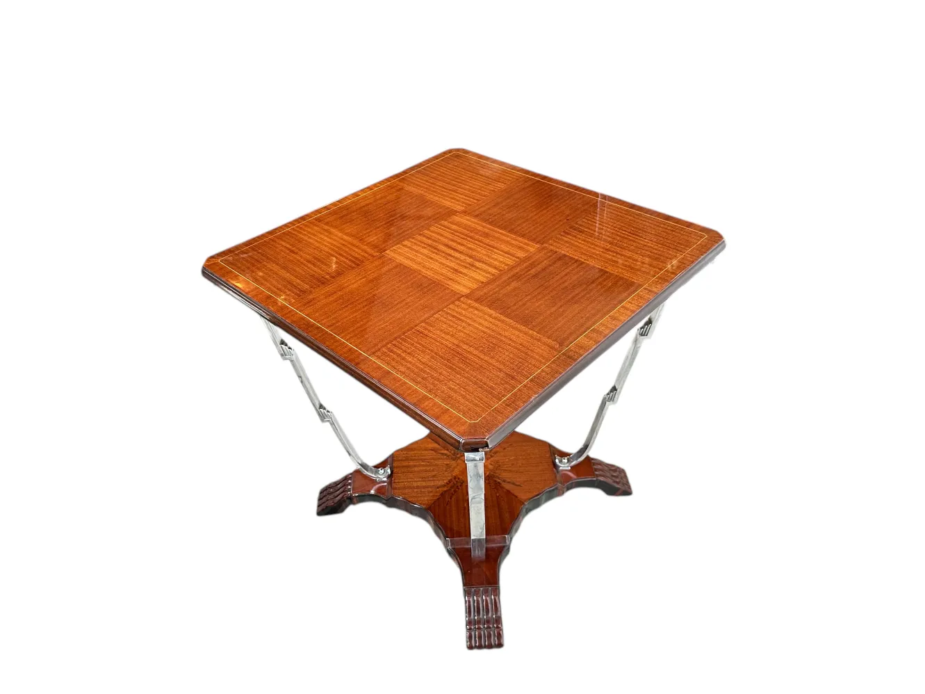 Una antigua mesita de forma cuadrada con acabados decorativos en su superficie.