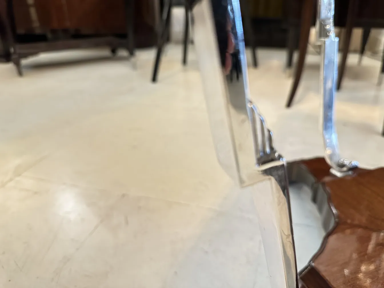 vista laterale di un tavolino antico con bordi eleganti in un ambiente accogliente