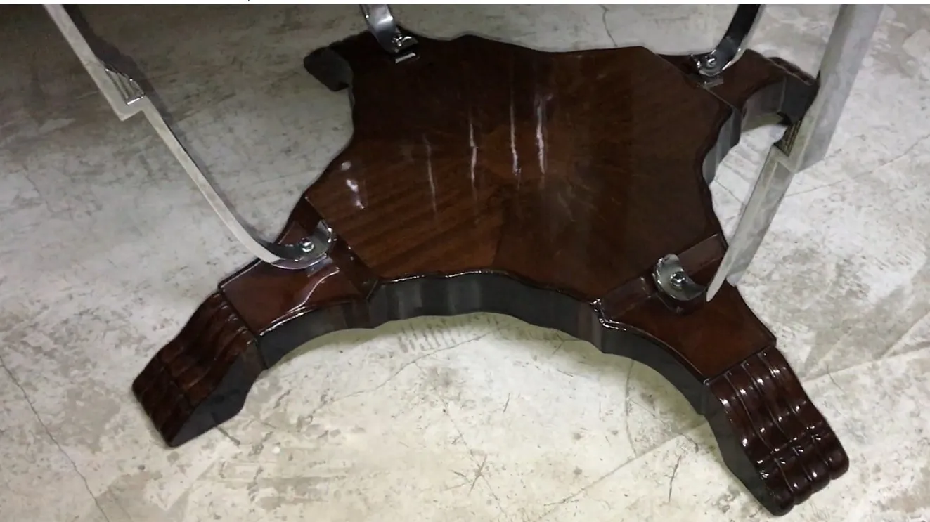 Antiker kleiner Tisch mit einem auffälligen Design und dekorativen Beinen in einer eleganten Umgebung.