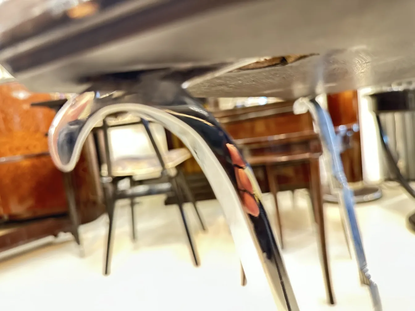 View of the base of an antique small table with curved legs, background with other furniture