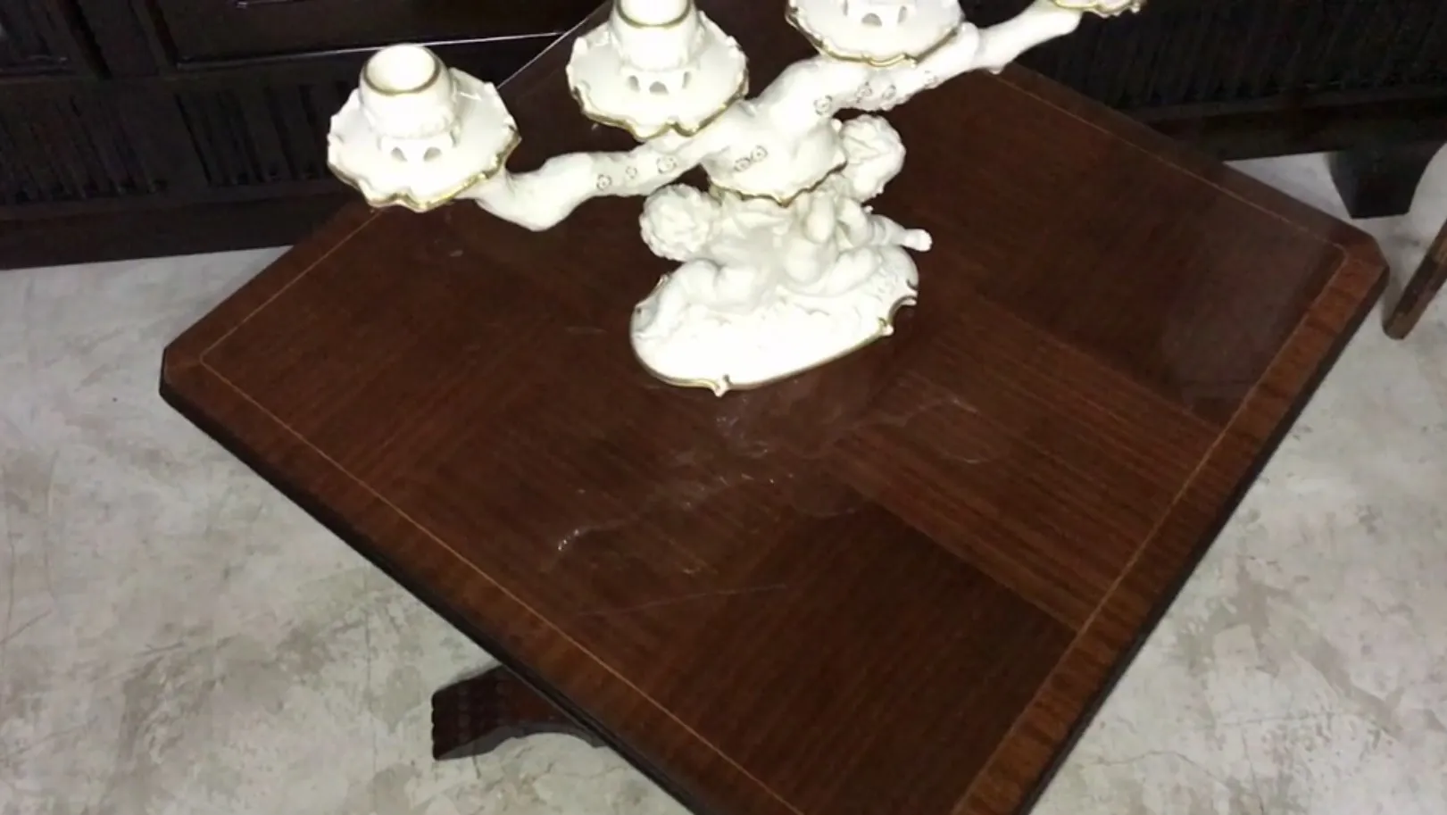 Petite table antique avec un candélabre décoratif au-dessus